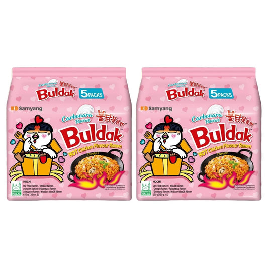 Two Samyang Buldak Carbonara hot chicken flavour instant ramen 5 pack bags in pink packaging, showing creamy stir fried noodles, halal certification and the Buldak chicken character illustration