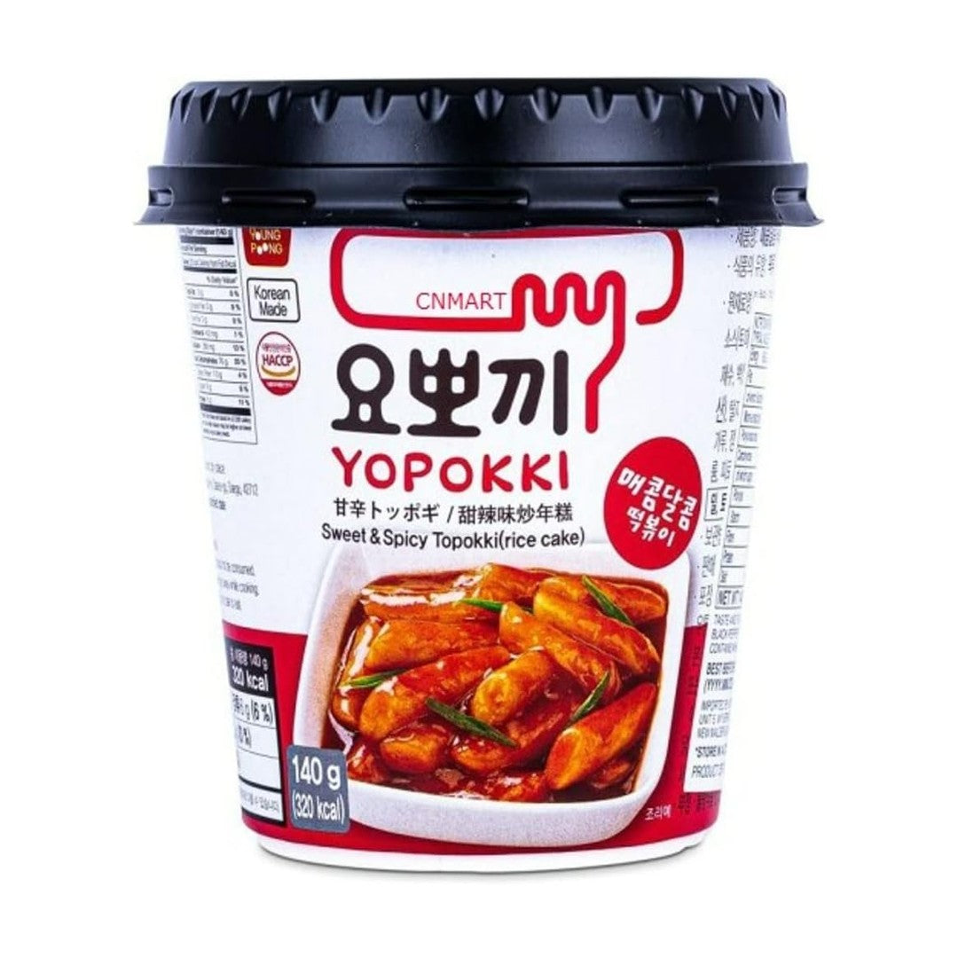 Yopokki Sweet & Spicy Topokki 140g instant cup with black microwave-style lid, showing product name in Korean and English with an image of cooked rice cakes in red sauce on the front label.